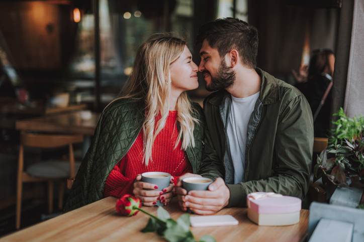 Beautiful young couple touching noses and smiling at cafe Beautiful young couple touching noses and smiling at cafe