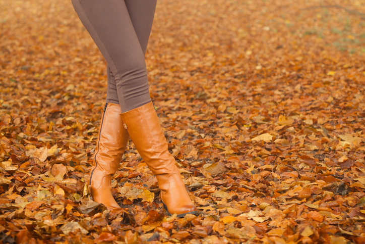 Closeup of woman legs in brown boots. Fall fashion