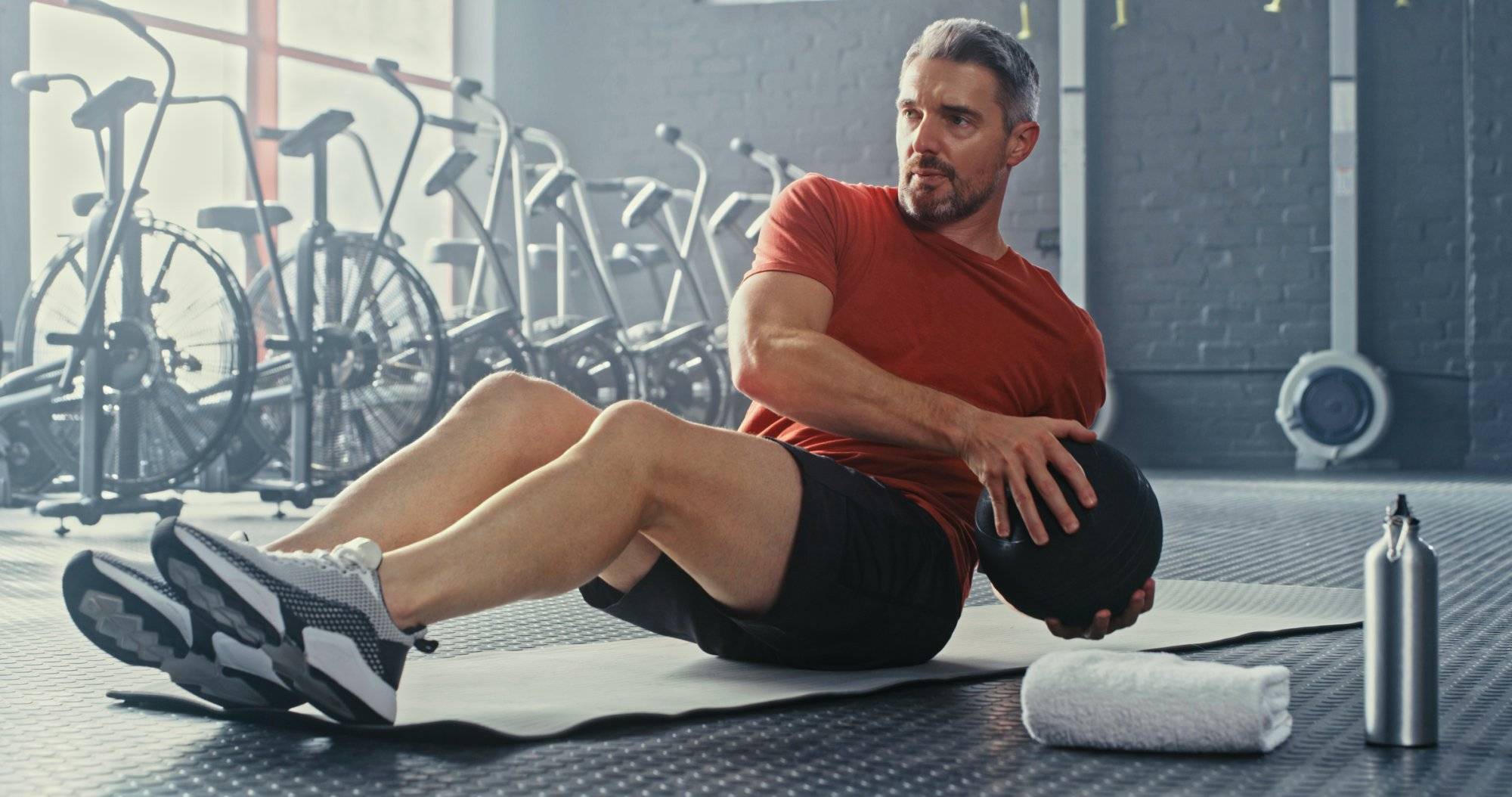 Shot of a handsome mature man using a medicine ball during his workout in the gym